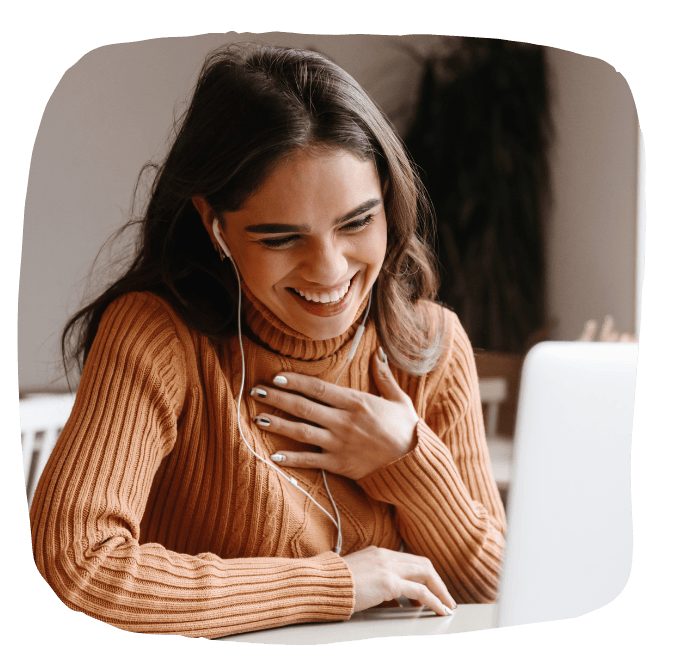 Woman smiling at laptop, hand on chest