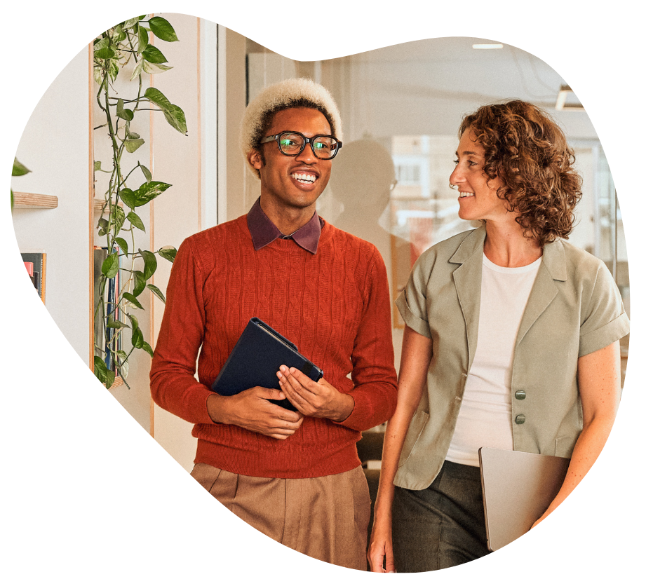 Two colleagues chatting casually while walking down a hallway